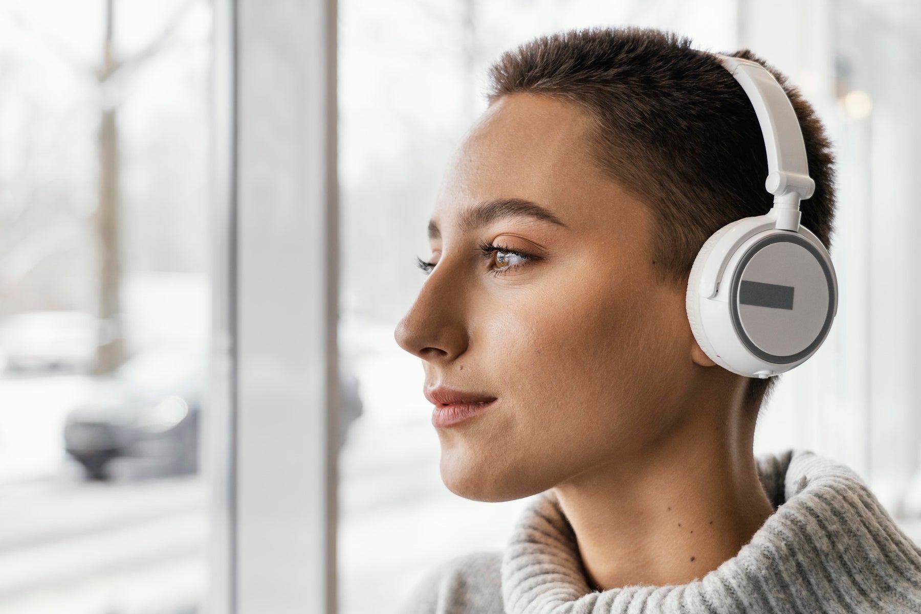 Person wearing noise-canceling headphones indoors, illustrating the difference between active noise canceling technology and certified hearing protection devices
