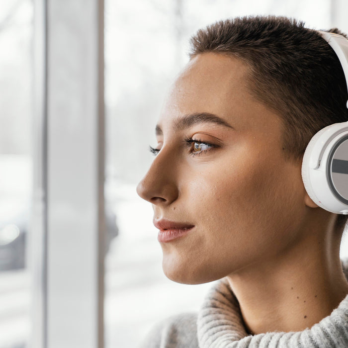 Person wearing noise-canceling headphones indoors, illustrating the difference between active noise canceling technology and certified hearing protection devices